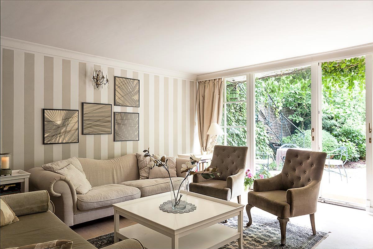 the living room inside of a home with one of the walls painted with vertical colored stripes